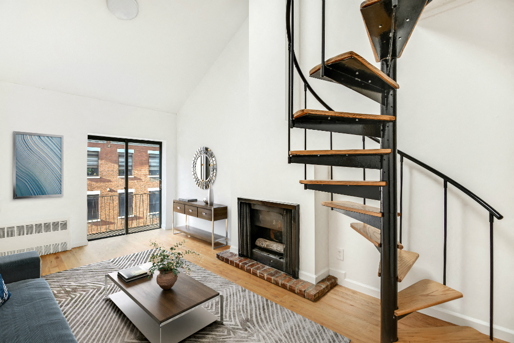 a living room with a spiral staircase and a brick fireplace